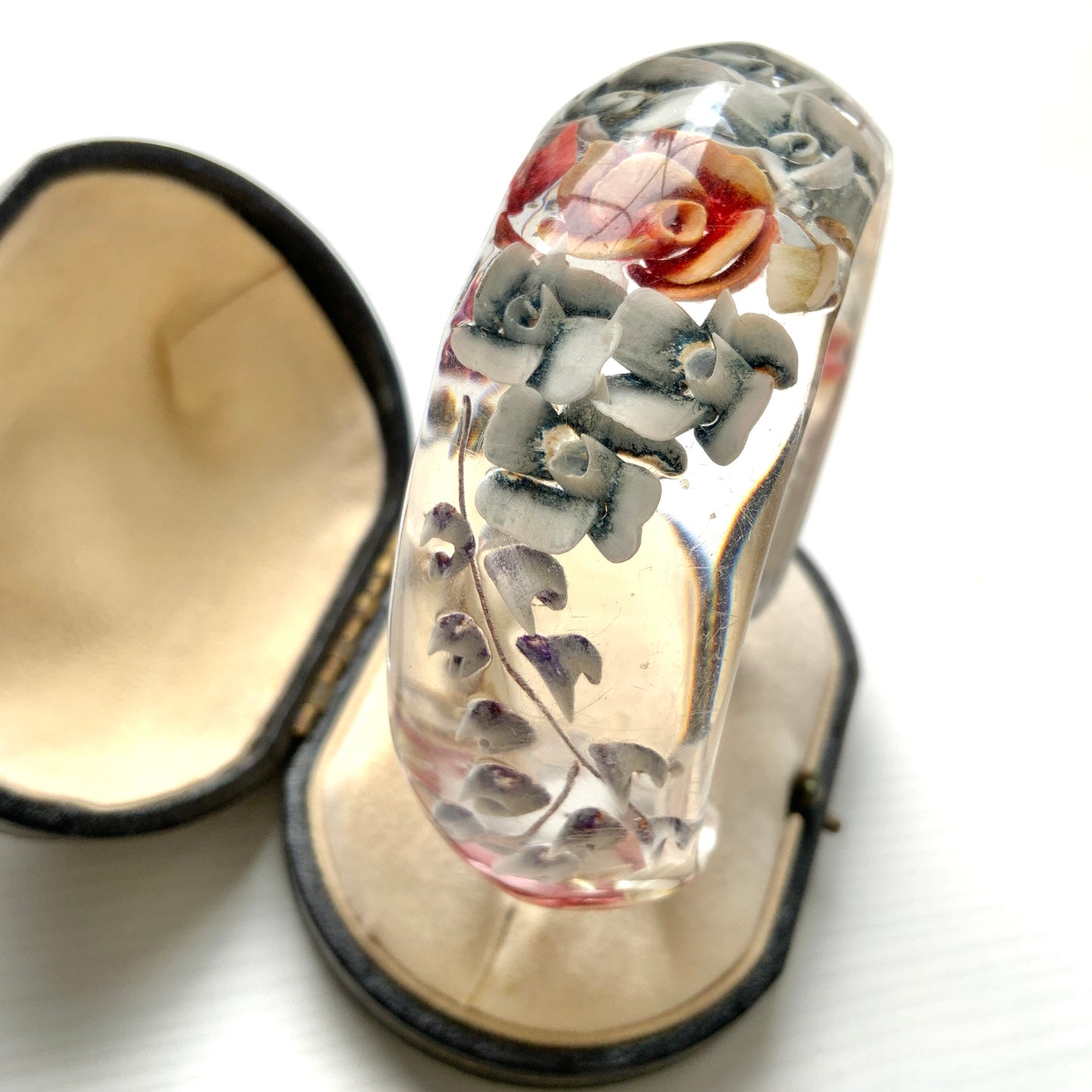 A vintage lucite bangle featuring carved and painted rose intaglios. クリアルーサイトに薔薇のインタリオが施されたヴィンテージバングル。