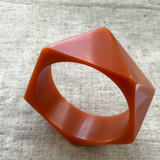 A bold faceted bangle in a unique burnt orange — or perhaps a rich caramel brown — early plastic. 個性的なバーントオレンジ、もしくはキャラメルブラウンのファセットバングル。