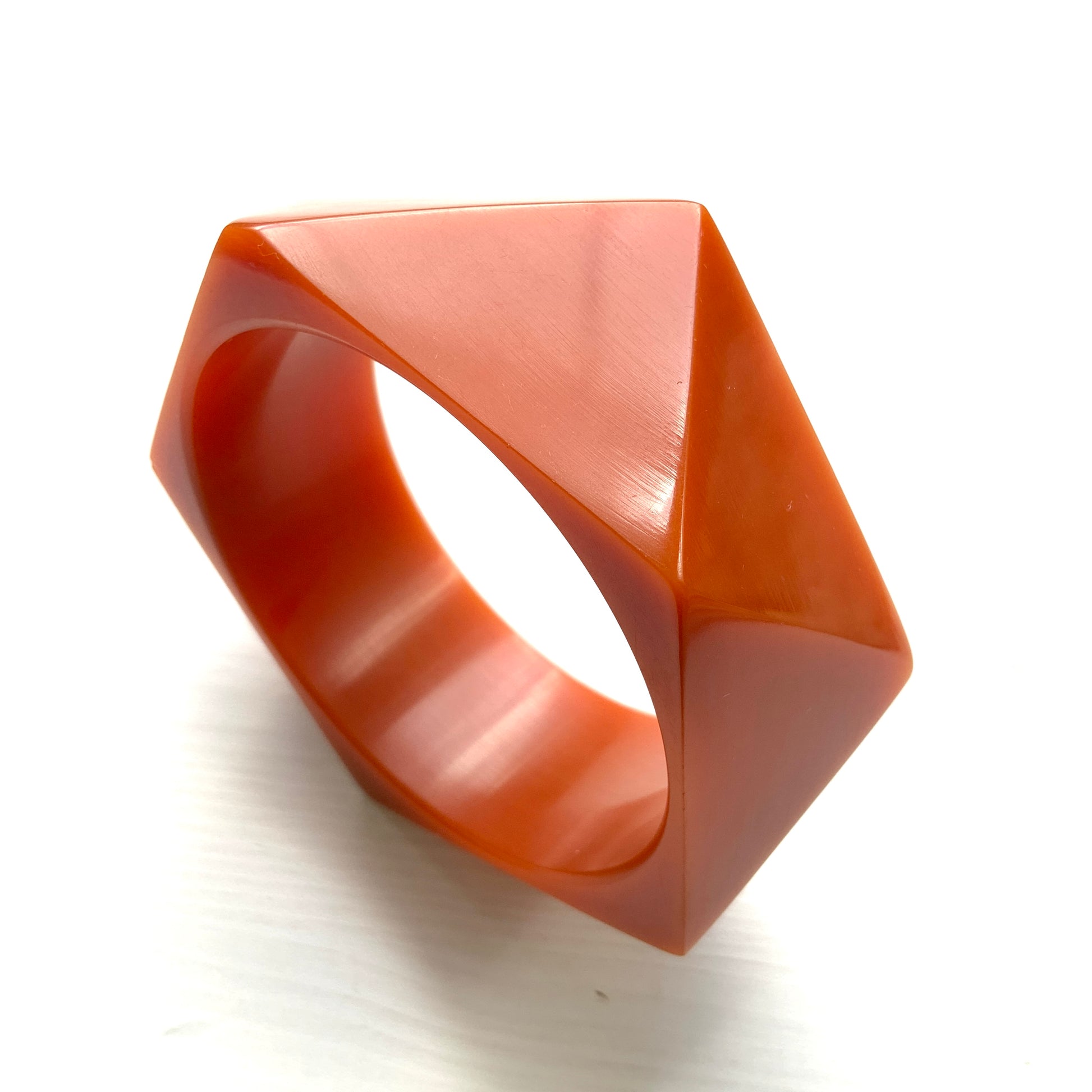 A bold faceted bangle in a unique burnt orange — or perhaps a rich caramel brown — early plastic. 個性的なバーントオレンジ、もしくはキャラメルブラウンのファセットバングル。