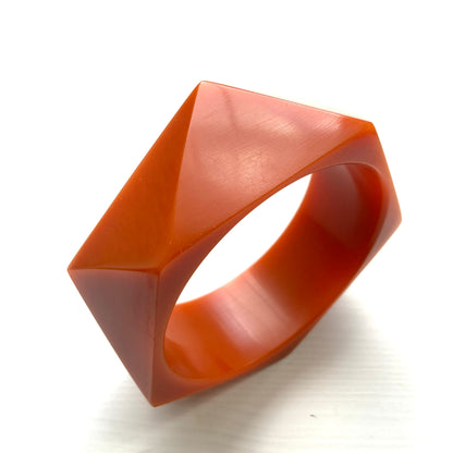 A bold faceted bangle in a unique burnt orange — or perhaps a rich caramel brown — early plastic. 個性的なバーントオレンジ、もしくはキャラメルブラウンのファセットバングル。