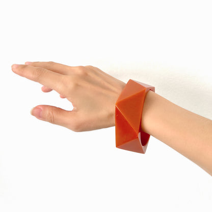 A bold faceted bangle in a unique burnt orange — or perhaps a rich caramel brown — early plastic. 個性的なバーントオレンジ、もしくはキャラメルブラウンのファセットバングル。