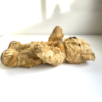 A small vintage teddy bear with the sweetest little smiling mouth.Softened by time, with slightly shrunken stuffing — all part of its charm. 小さな口元がにっこりと微笑んでいる、小さなヴィンテージテディベア。