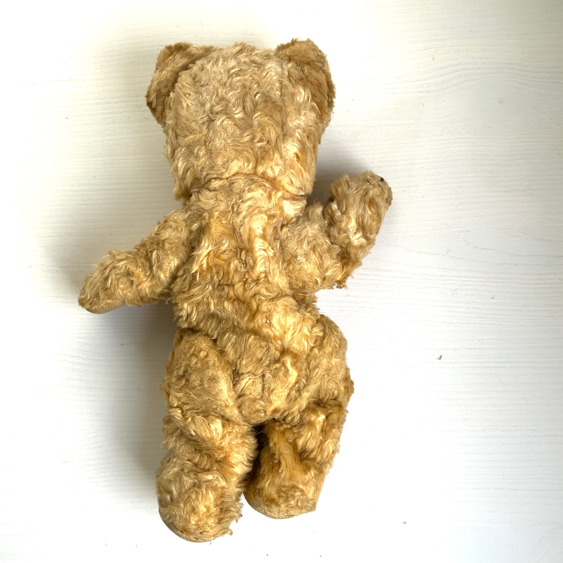 A small vintage teddy bear with the sweetest little smiling mouth.Softened by time, with slightly shrunken stuffing — all part of its charm. 小さな口元がにっこりと微笑んでいる、小さなヴィンテージテディベア。