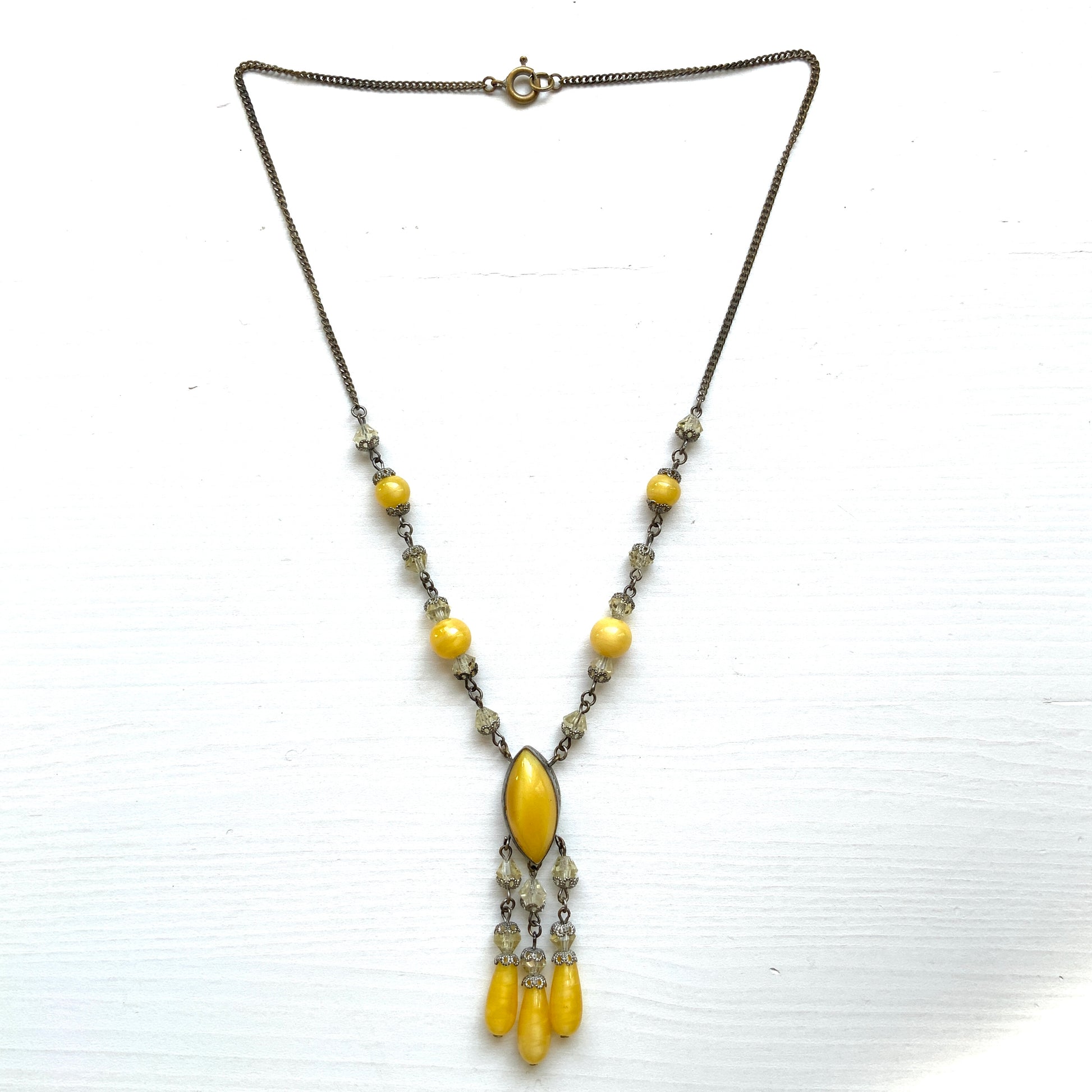 A 1930s necklace featuring soft butterscotch yellow satin glass, paired with delicate filigree details and clear glass accents. やわらかなバタースコッチイエローのサテンガラスに、繊細なフィリグリーパーツとクリアガラスを合わせた1930年代頃のネックレス。