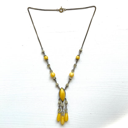 A 1930s necklace featuring soft butterscotch yellow satin glass, paired with delicate filigree details and clear glass accents. やわらかなバタースコッチイエローのサテンガラスに、繊細なフィリグリーパーツとクリアガラスを合わせた1930年代頃のネックレス。