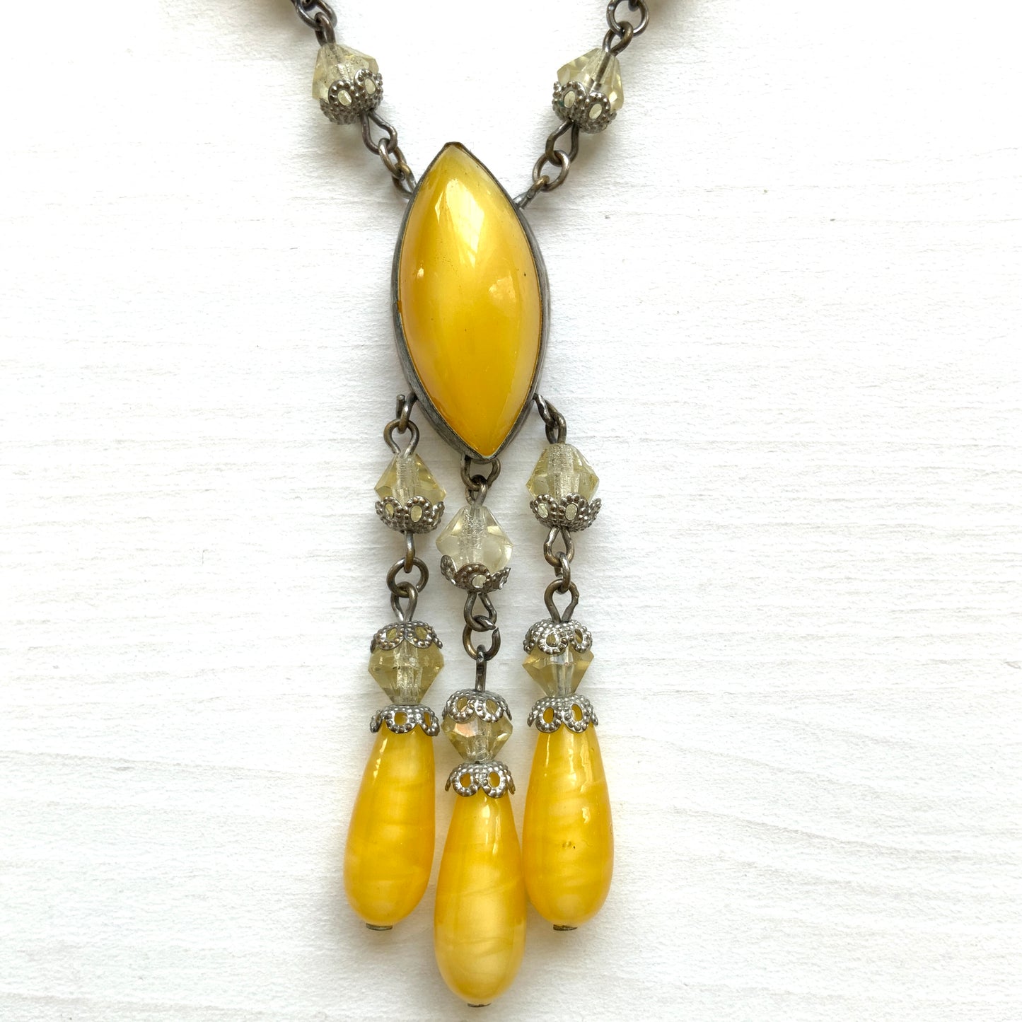 A 1930s necklace featuring soft butterscotch yellow satin glass, paired with delicate filigree details and clear glass accents. やわらかなバタースコッチイエローのサテンガラスに、繊細なフィリグリーパーツとクリアガラスを合わせた1930年代頃のネックレス。