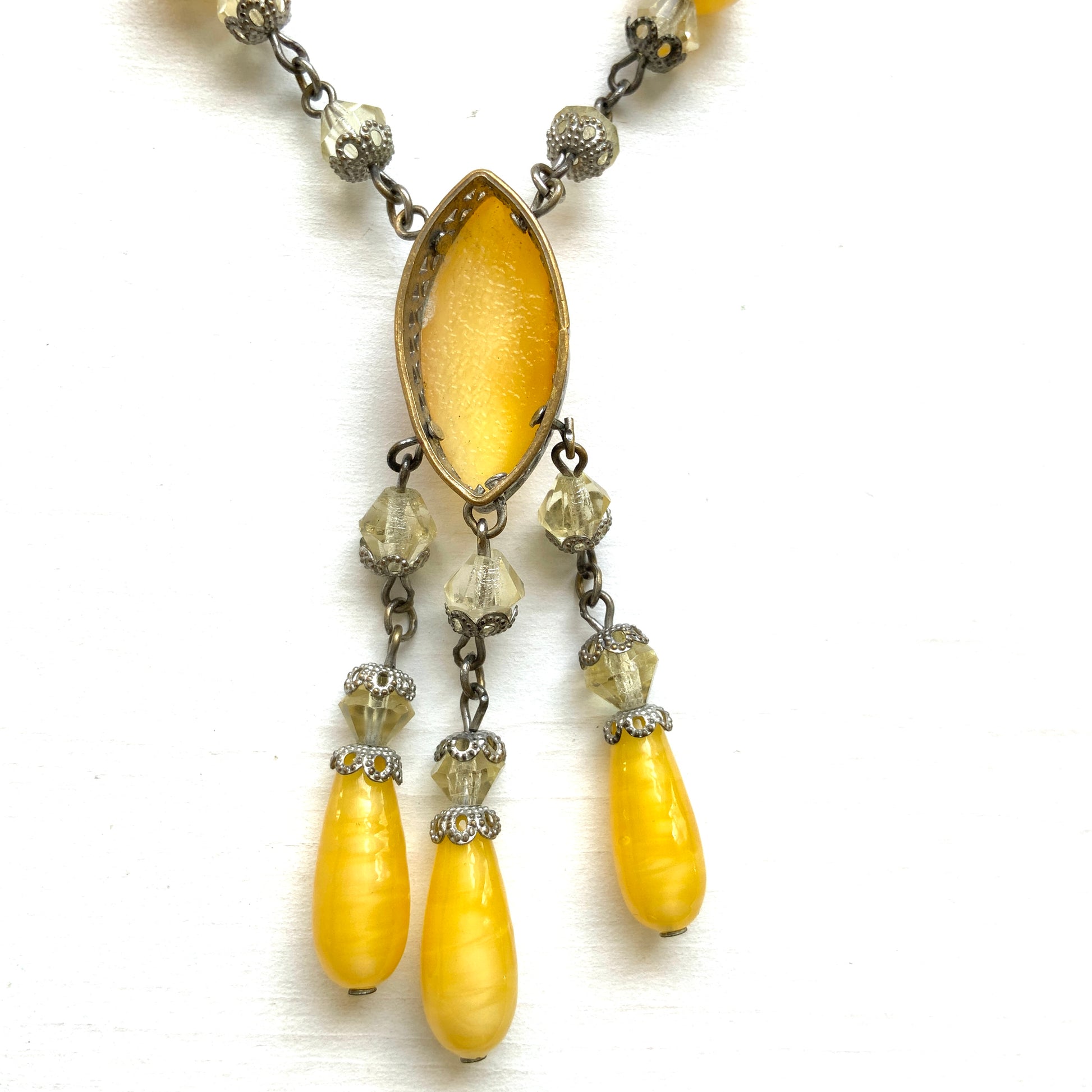 A 1930s necklace featuring soft butterscotch yellow satin glass, paired with delicate filigree details and clear glass accents. やわらかなバタースコッチイエローのサテンガラスに、繊細なフィリグリーパーツとクリアガラスを合わせた1930年代頃のネックレス。