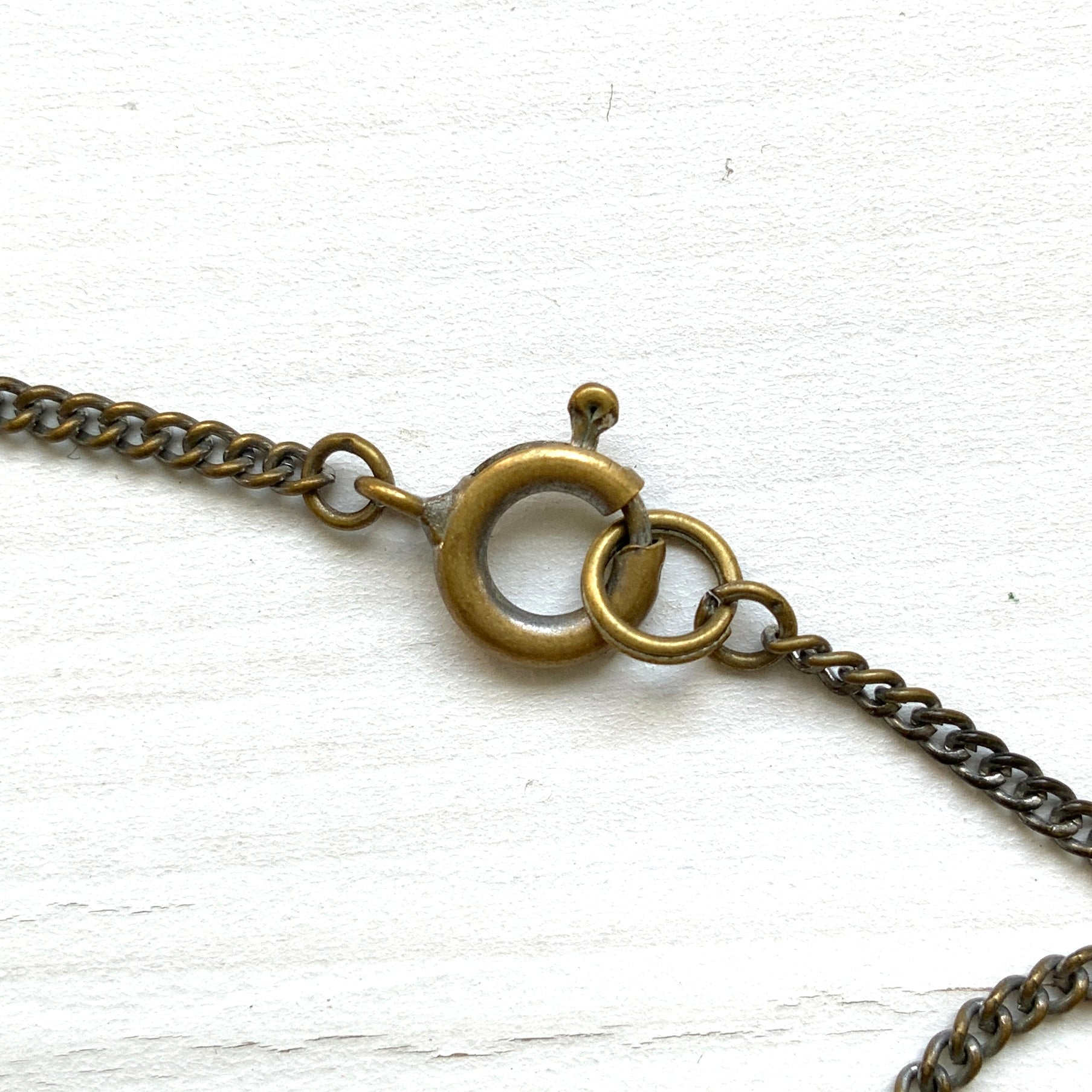 A 1930s necklace featuring soft butterscotch yellow satin glass, paired with delicate filigree details and clear glass accents. やわらかなバタースコッチイエローのサテンガラスに、繊細なフィリグリーパーツとクリアガラスを合わせた1930年代頃のネックレス。
