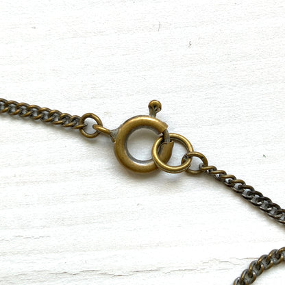 A 1930s necklace featuring soft butterscotch yellow satin glass, paired with delicate filigree details and clear glass accents. やわらかなバタースコッチイエローのサテンガラスに、繊細なフィリグリーパーツとクリアガラスを合わせた1930年代頃のネックレス。