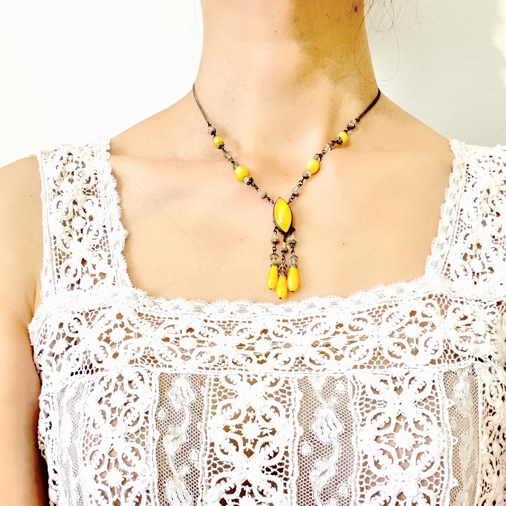 A 1930s necklace featuring soft butterscotch yellow satin glass, paired with delicate filigree details and clear glass accents. やわらかなバタースコッチイエローのサテンガラスに、繊細なフィリグリーパーツとクリアガラスを合わせた1930年代頃のネックレス。