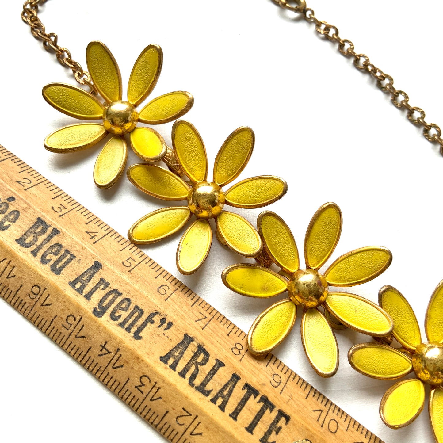 A vintage necklace featuring linked yellow enamel flowers. イエローのエナメルフラワーが連なったヴィンテージネックレス。