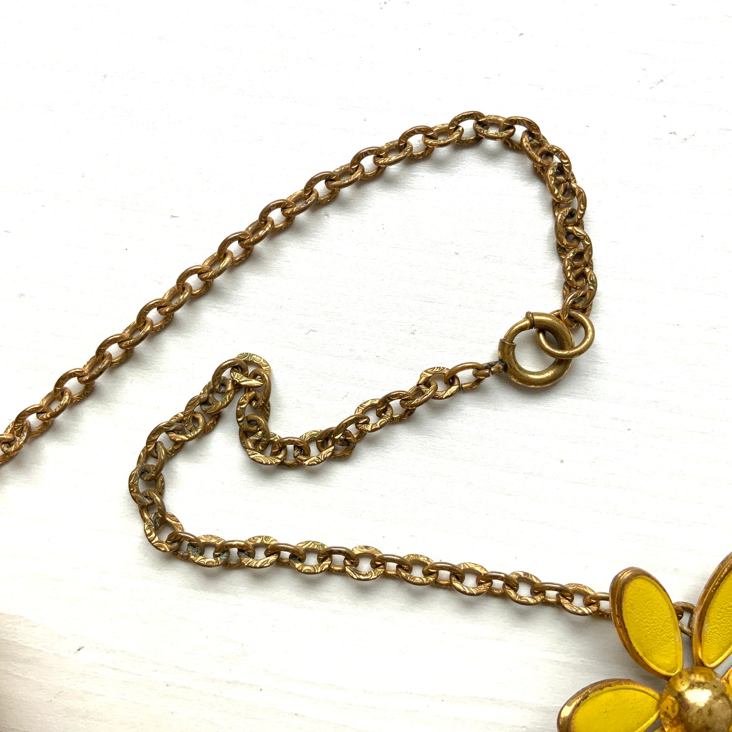 A vintage necklace featuring linked yellow enamel flowers. イエローのエナメルフラワーが連なったヴィンテージネックレス。