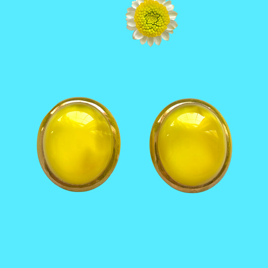 Lemon yellow satin glass clip-on earrings featuring large, smooth cabochons with a beautifully soft sheen unique to satin glass, reminiscent of silk or satin fabric. レモンイエローのサテンガラスのクリップイヤリング。