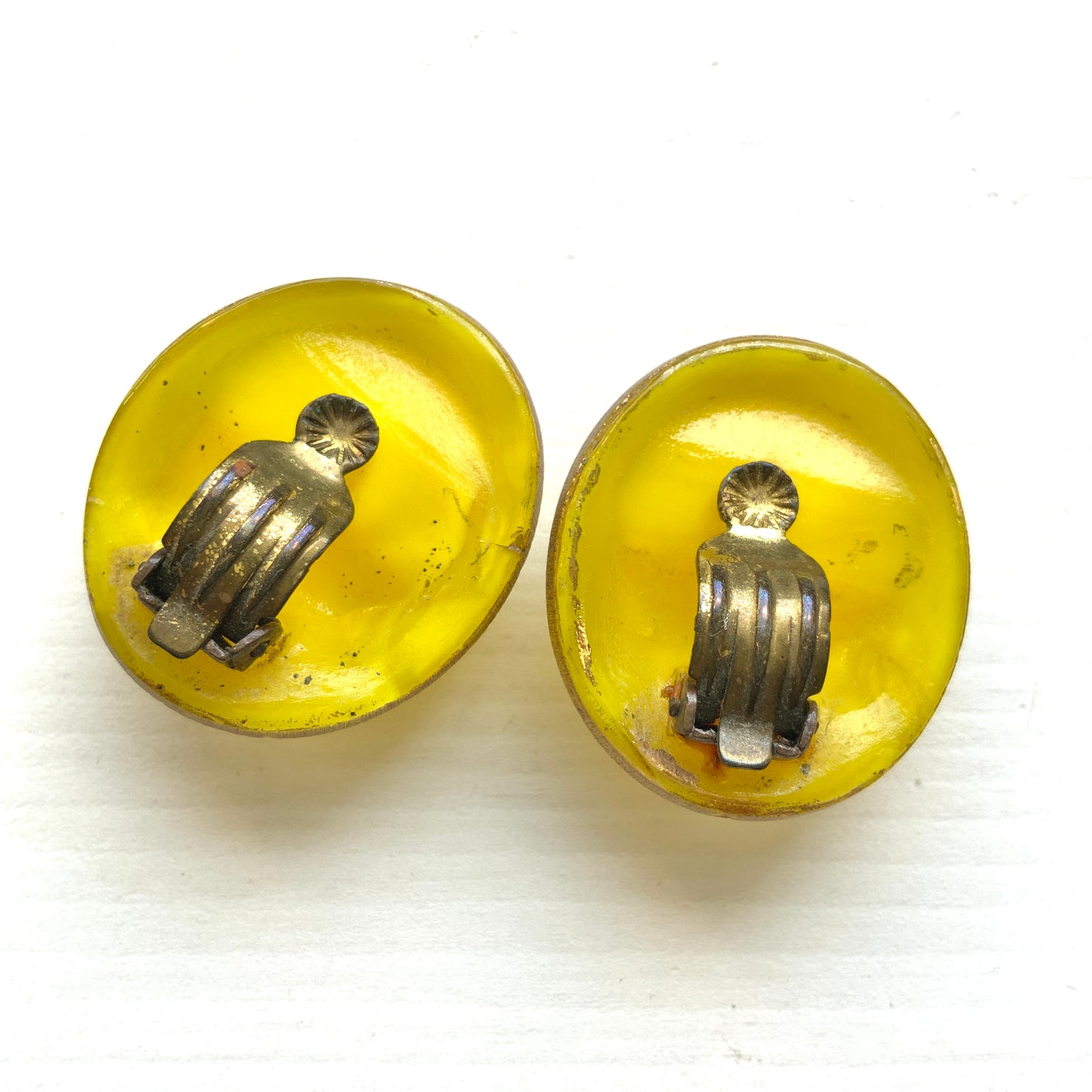 Lemon yellow satin glass clip-on earrings featuring large, smooth cabochons with a beautifully soft sheen unique to satin glass, reminiscent of silk or satin fabric. レモンイエローのサテンガラスのクリップイヤリング。