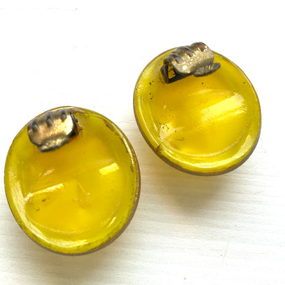 Lemon yellow satin glass clip-on earrings featuring large, smooth cabochons with a beautifully soft sheen unique to satin glass, reminiscent of silk or satin fabric. レモンイエローのサテンガラスのクリップイヤリング。