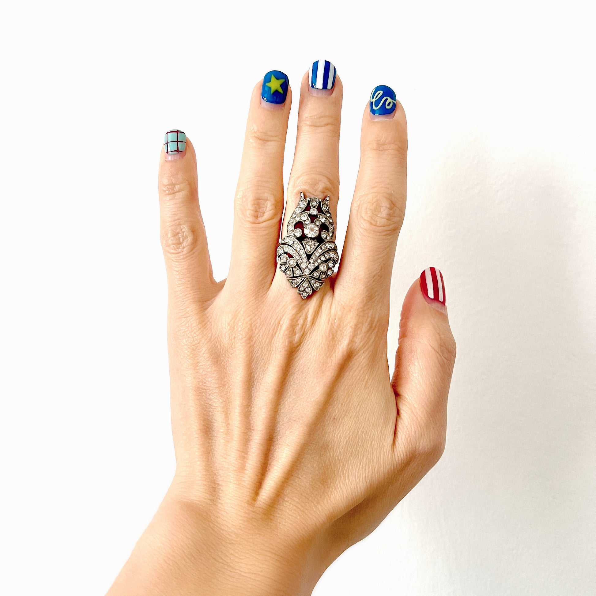 A striking vintage ring adorned with intricate scrollwork and densely set clear rhinestones. 細やかなスクロール装飾にクリアラインストーンがぎっしりと敷き詰められた、存在感たっぷりのヴィンテージリング。