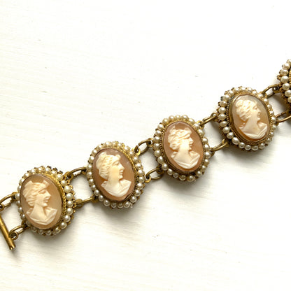 A bracelet lavishly set with seven shell cameos, each delicately framed with tiny glass pearls.  七つのシェルカメオを贅沢に連ねたブレスレット。 