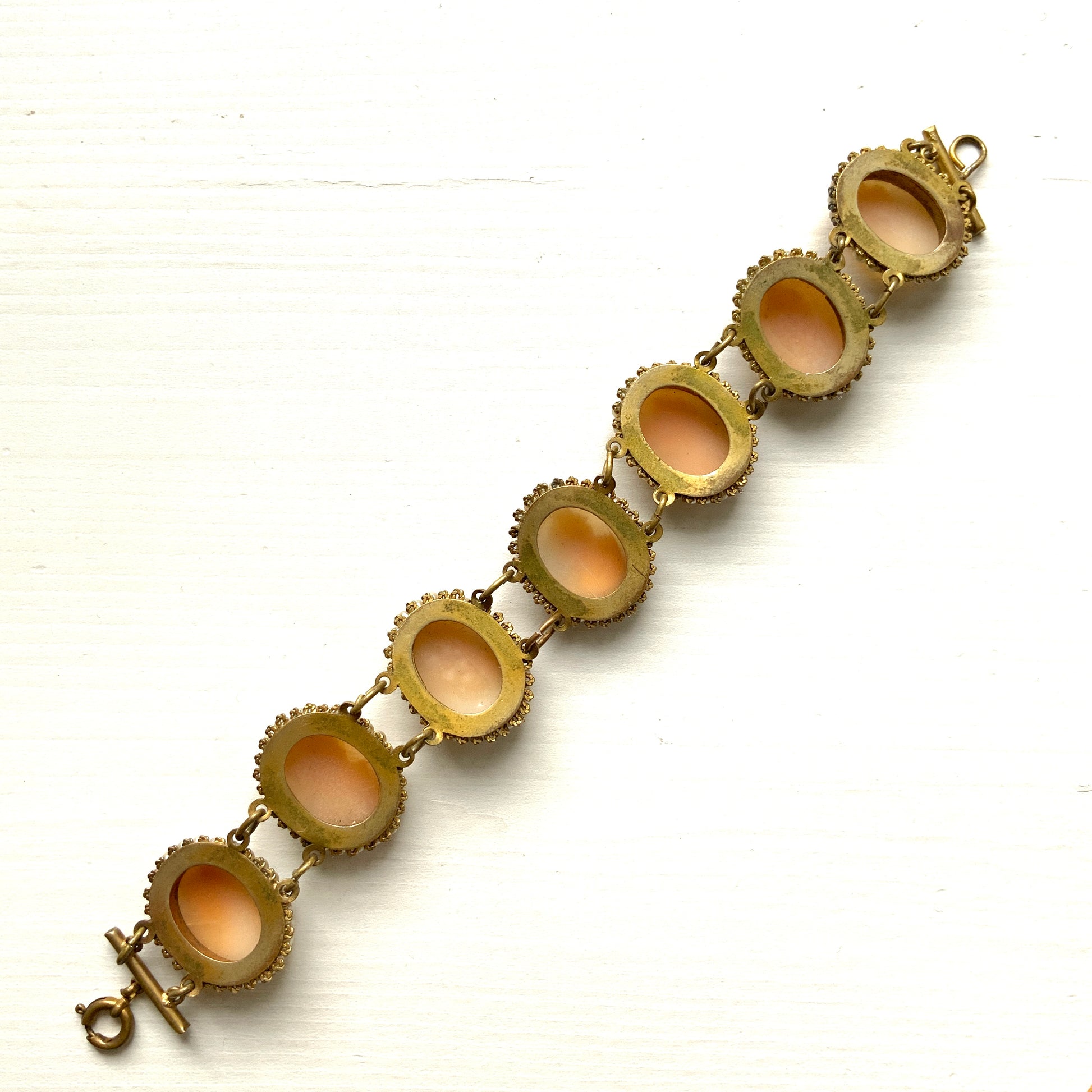A bracelet lavishly set with seven shell cameos, each delicately framed with tiny glass pearls.  七つのシェルカメオを贅沢に連ねたブレスレット。 
