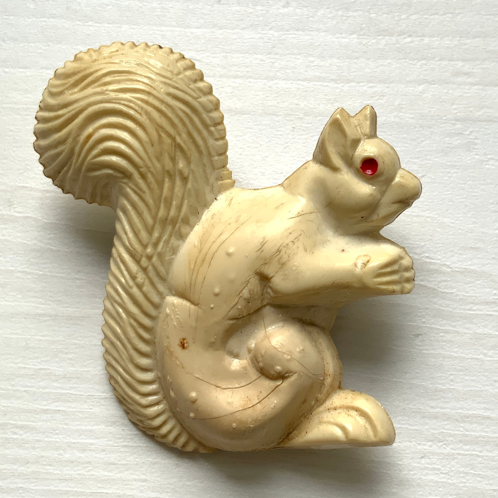 A charming white celluloid squirrel brooch with a softly rounded body. ふっくらとしたボディが愛らしい、白いセルロイド製のリスのブローチ。