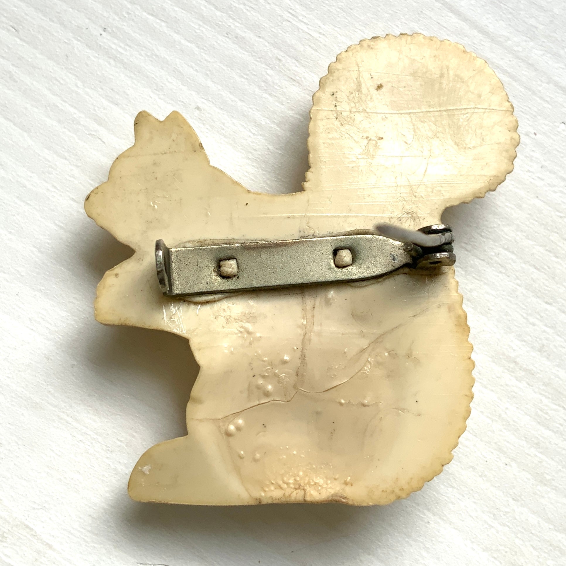A charming white celluloid squirrel brooch with a softly rounded body. ふっくらとしたボディが愛らしい、白いセルロイド製のリスのブローチ。
