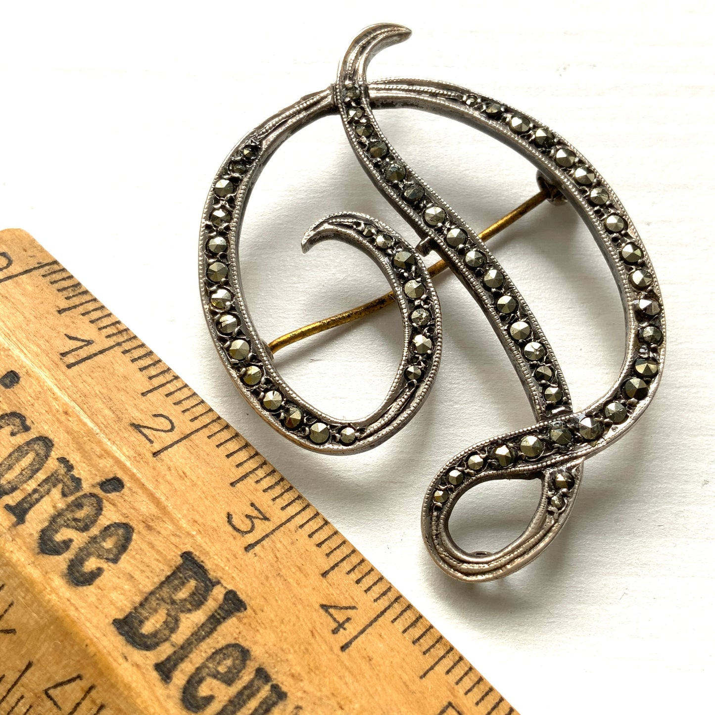 A silver brooch in the shape of the letter “D”, adorned with marcasites. マーカサイトが散りばめられた、シルバーの”D"のブローチ