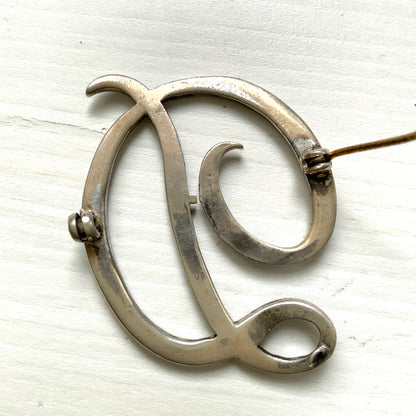  A silver brooch in the shape of the letter “D”, adorned with marcasites. マーカサイトが散りばめられた、シルバーの”D"のブローチ