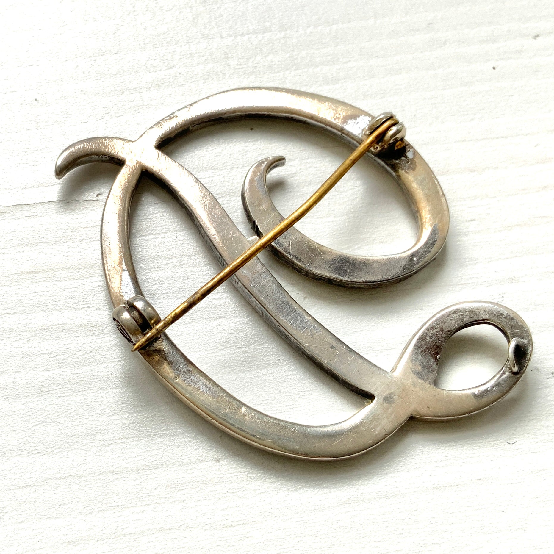  A silver brooch in the shape of the letter “D”, adorned with marcasites. マーカサイトが散りばめられた、シルバーの”D"のブローチ