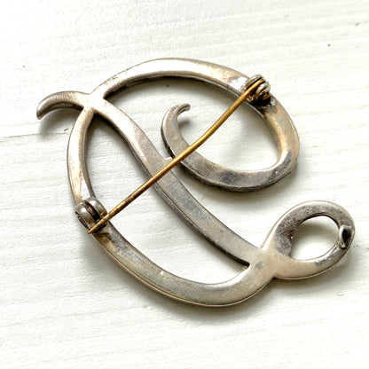  A silver brooch in the shape of the letter “D”, adorned with marcasites. マーカサイトが散りばめられた、シルバーの”D"のブローチ