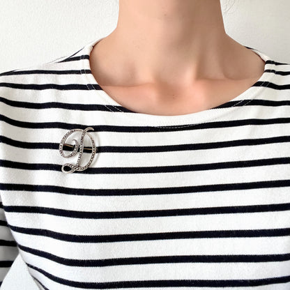  A silver brooch in the shape of the letter “D”, adorned with marcasites. マーカサイトが散りばめられた、シルバーの”D"のブローチ