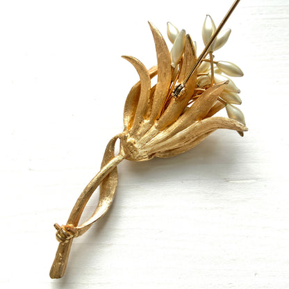 A vintage floral brooch featuring beautiful gold tones and glass pearls. ゴールドトーンとグラスパールが美しいフラワーモチーフのヴィンテージブローチ。