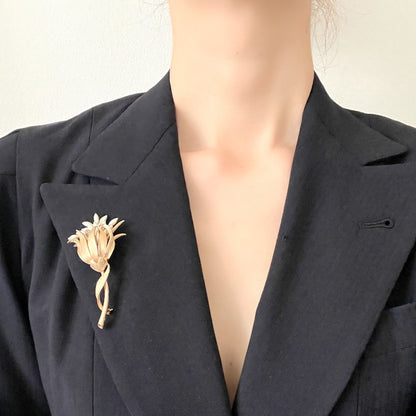 A vintage floral brooch featuring beautiful gold tones and glass pearls. ゴールドトーンとグラスパールが美しいフラワーモチーフのヴィンテージブローチ。