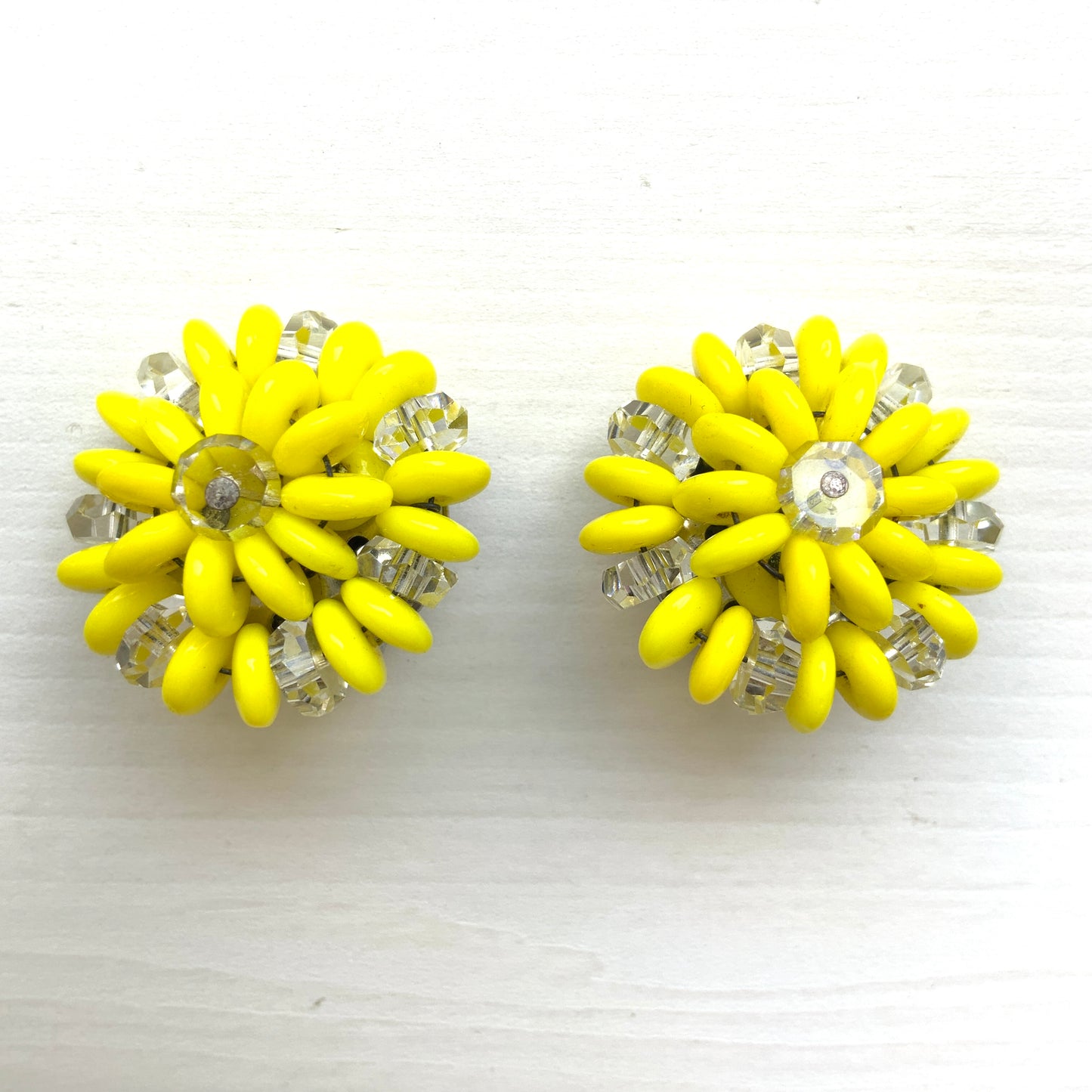 Laguna clip-on earrings featuring vibrant neon yellow beads paired with faceted clear glass accents. 鮮やかなネオンイエローとクリアビーズを組み合わせた、Lagunaのクリップイヤリング。