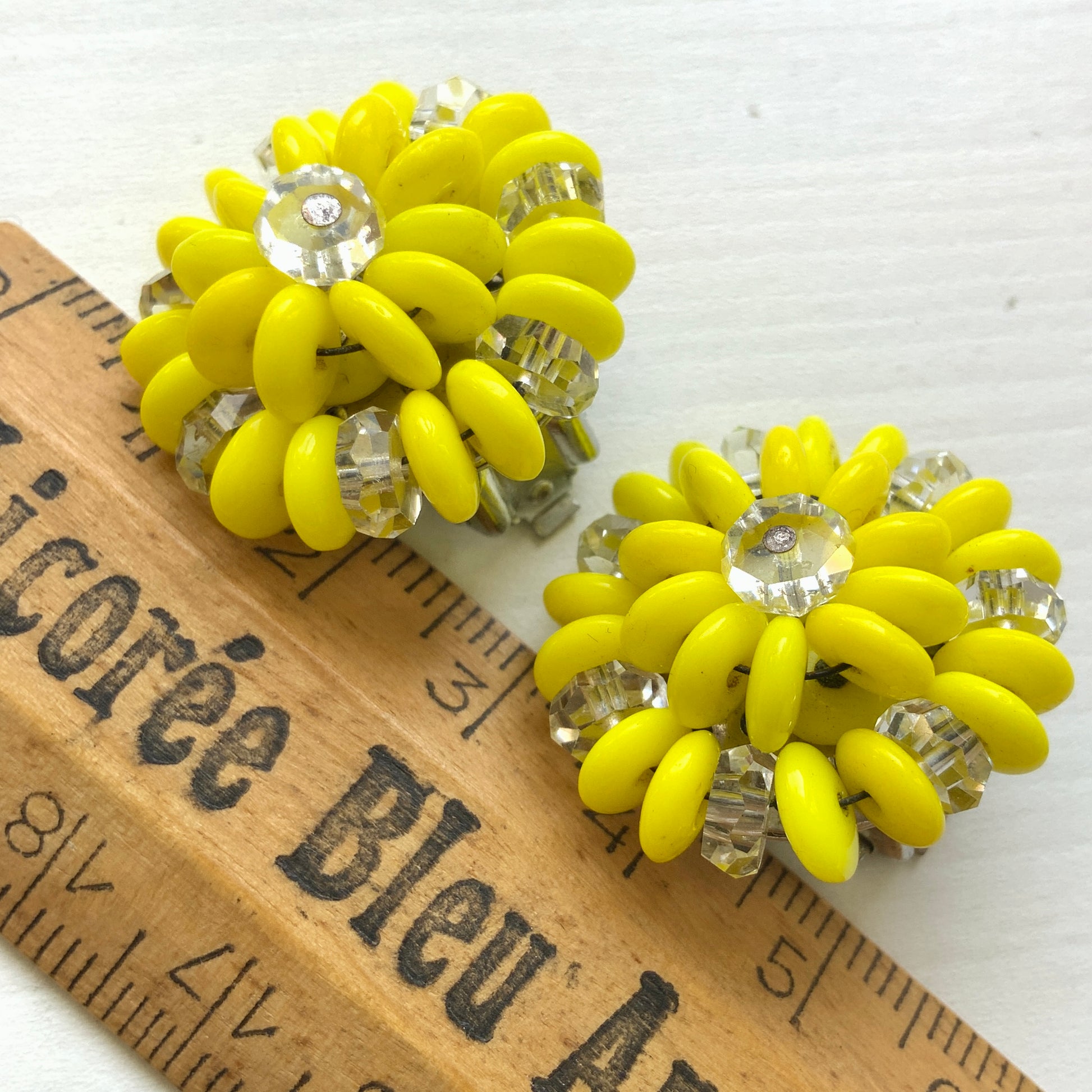 Laguna clip-on earrings featuring vibrant neon yellow beads paired with faceted clear glass accents. 鮮やかなネオンイエローとクリアビーズを組み合わせた、Lagunaのクリップイヤリング。