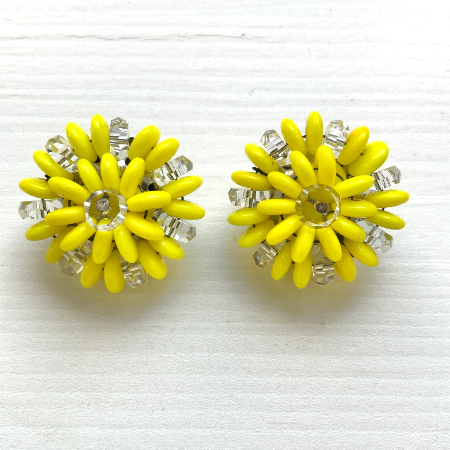 Laguna clip-on earrings featuring vibrant neon yellow beads paired with faceted clear glass accents. 鮮やかなネオンイエローとクリアビーズを組み合わせた、Lagunaのクリップイヤリング。