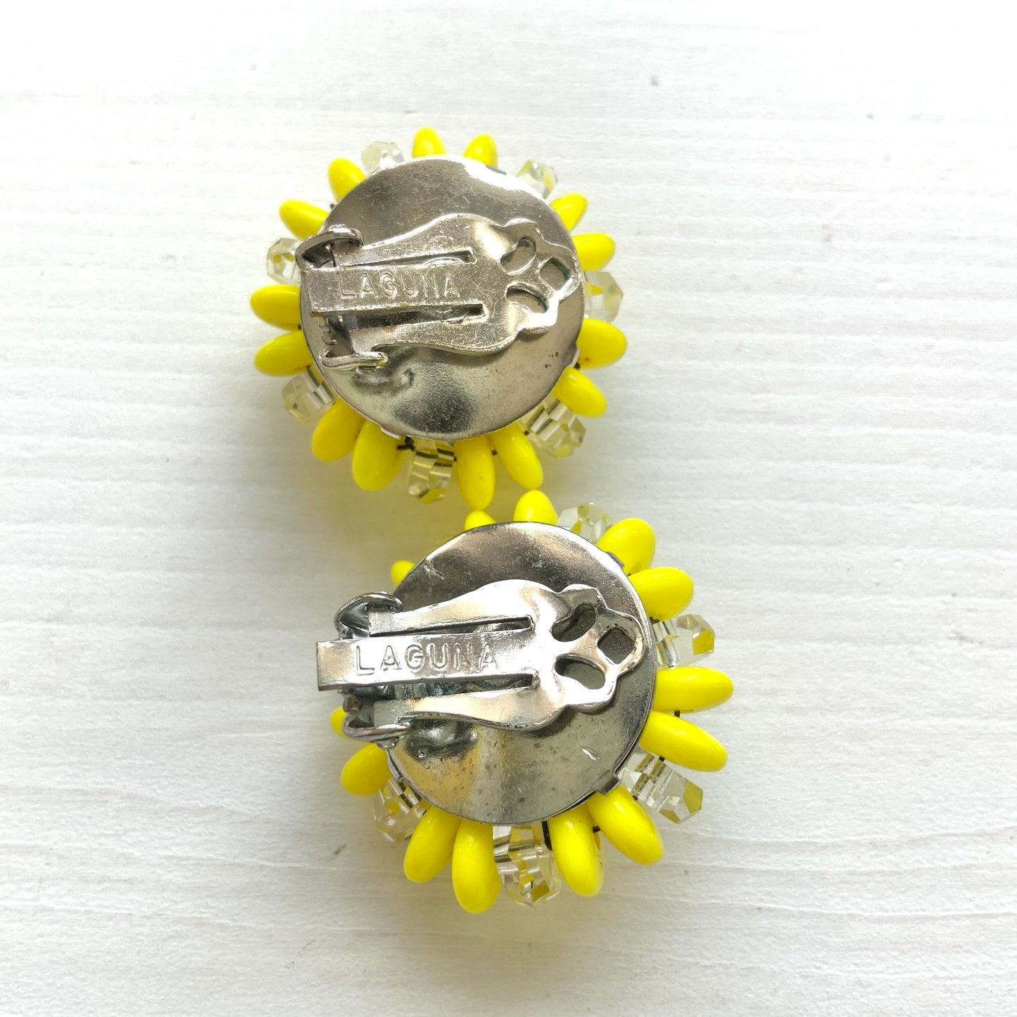 Laguna clip-on earrings featuring vibrant neon yellow beads paired with faceted clear glass accents. 鮮やかなネオンイエローとクリアビーズを組み合わせた、Lagunaのクリップイヤリング。