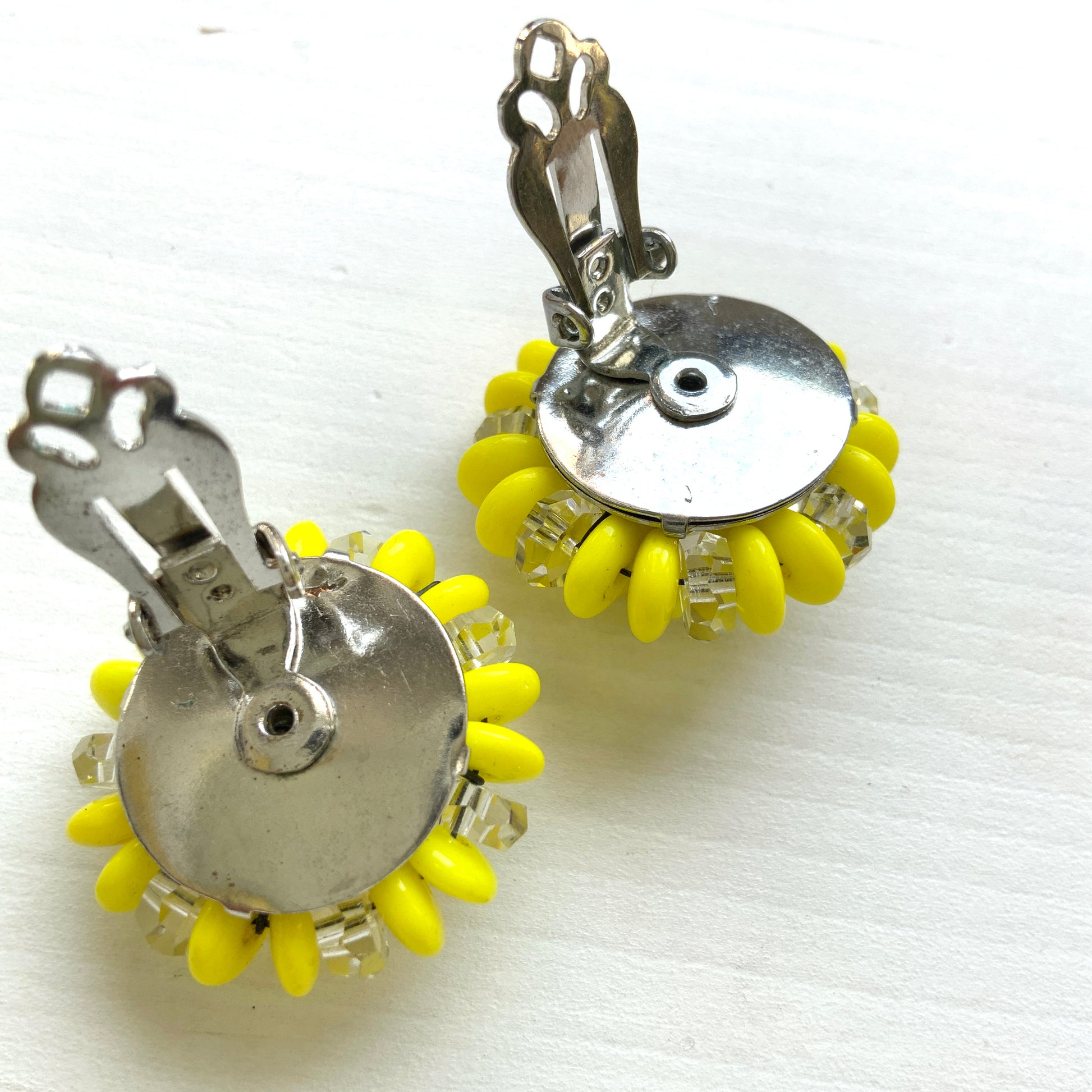 Laguna clip-on earrings featuring vibrant neon yellow beads paired with faceted clear glass accents. 鮮やかなネオンイエローとクリアビーズを組み合わせた、Lagunaのクリップイヤリング。