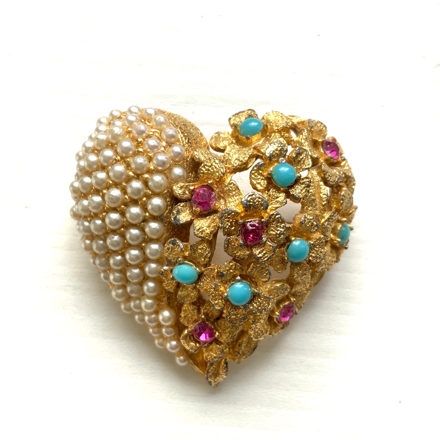A gold-tone heart brooch featuring delicate floral motifs and seed pearls.  ゴールドトーンのお花とシードパールを組み合わせた、ハートモチーフのブローチ。 