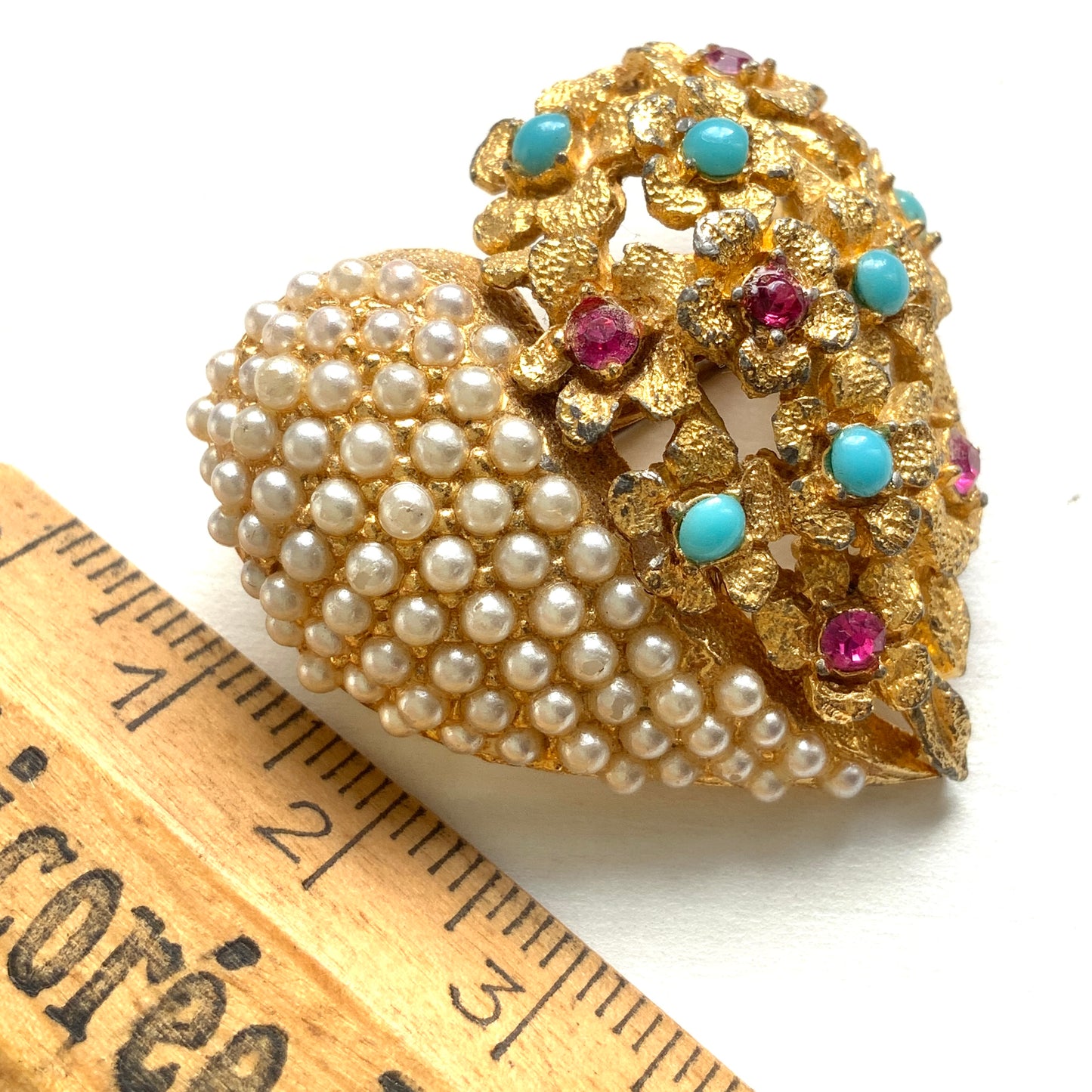 A gold-tone heart brooch featuring delicate floral motifs and seed pearls.  ゴールドトーンのお花とシードパールを組み合わせた、ハートモチーフのブローチ。 