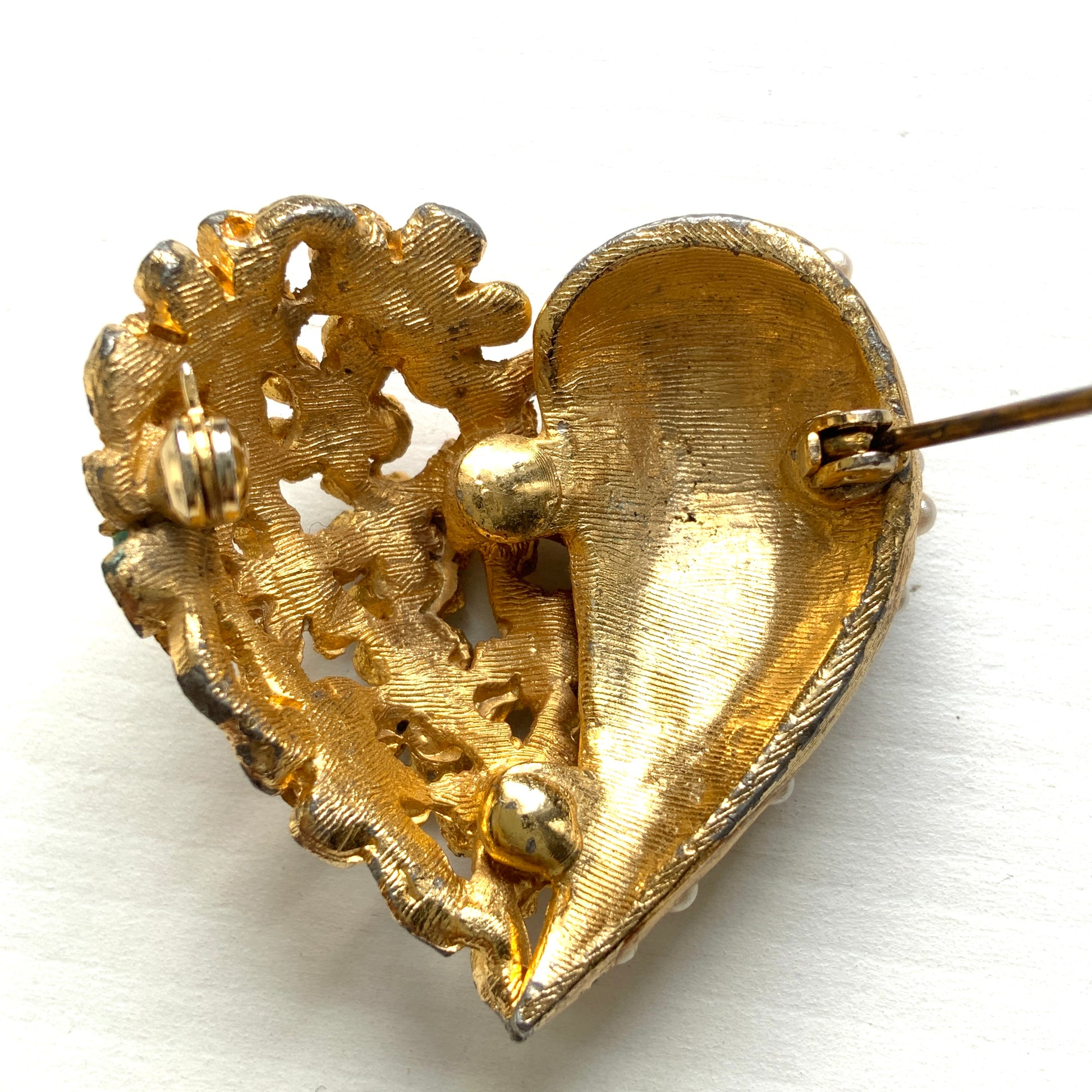 A gold-tone heart brooch featuring delicate floral motifs and seed pearls.  ゴールドトーンのお花とシードパールを組み合わせた、ハートモチーフのブローチ。 