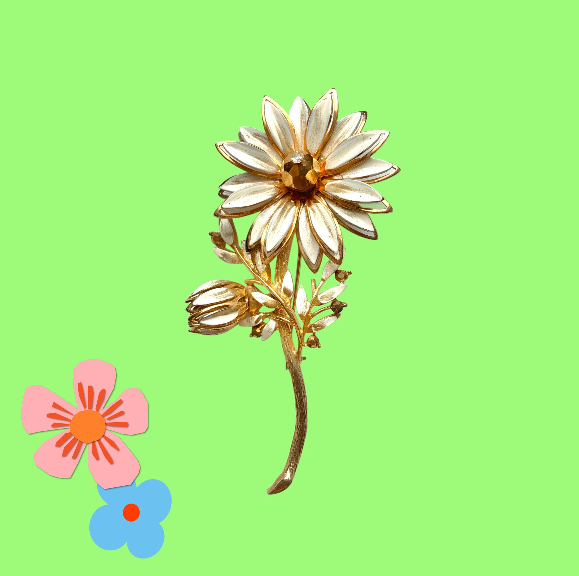 A large vintage brooch featuring white enamel flowers. ホワイトのエナメルフラワーがあしらわれた大ぶりのヴィンテージブローチ。 