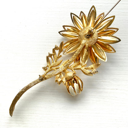 A large vintage brooch featuring white enamel flowers. ホワイトのエナメルフラワーがあしらわれた大ぶりのヴィンテージブローチ。 