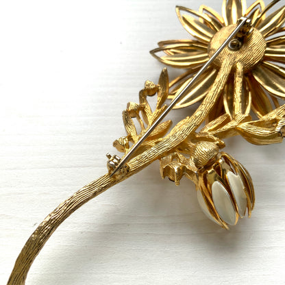 A large vintage brooch featuring white enamel flowers. ホワイトのエナメルフラワーがあしらわれた大ぶりのヴィンテージブローチ。 