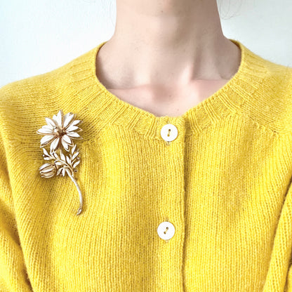 A large vintage brooch featuring white enamel flowers. ホワイトのエナメルフラワーがあしらわれた大ぶりのヴィンテージブローチ。 