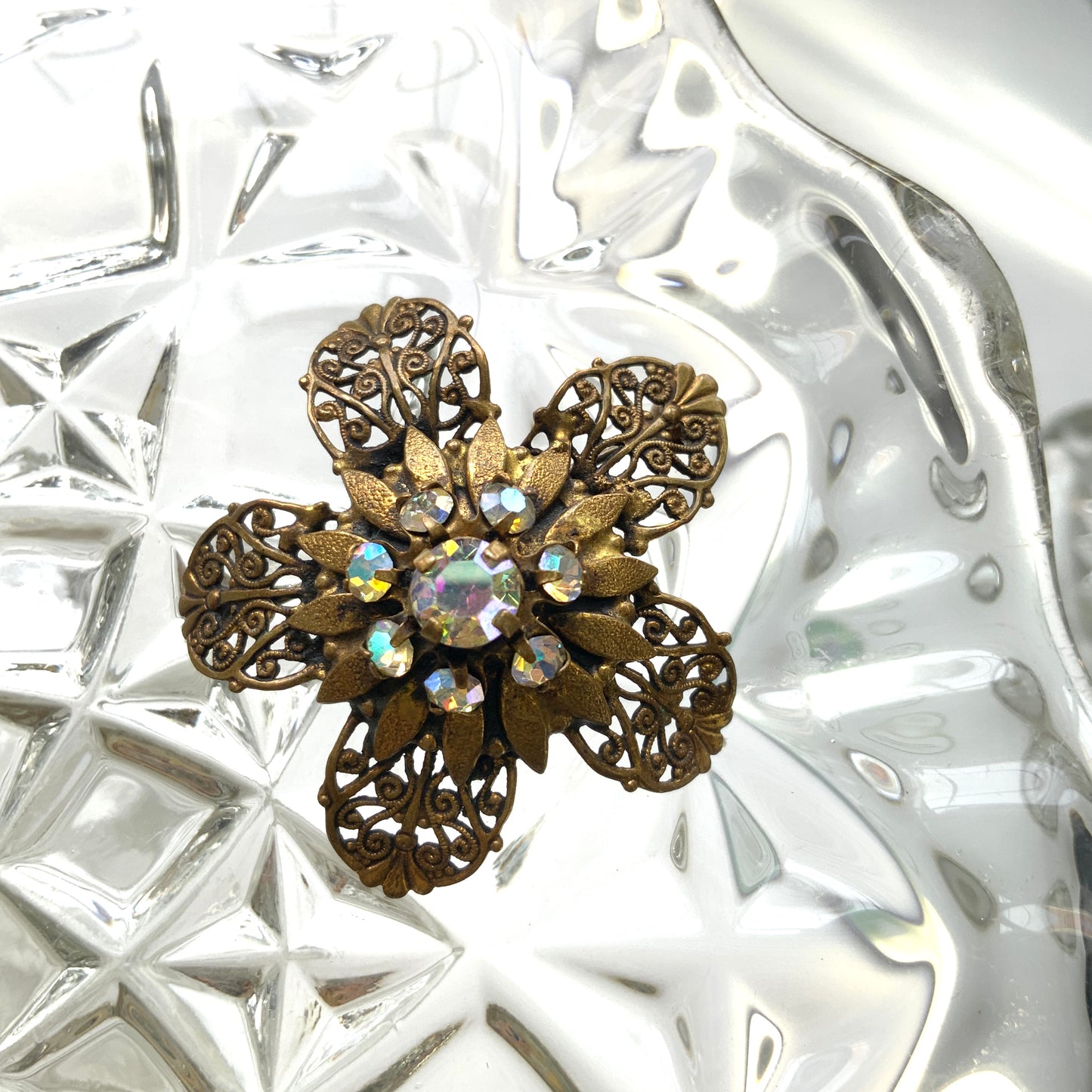 A beautifully detailed filigree flower brooch with a softly glowing aurora borealis centre.  フィリグリー×オーロラストーンのフラワーブローチ。
