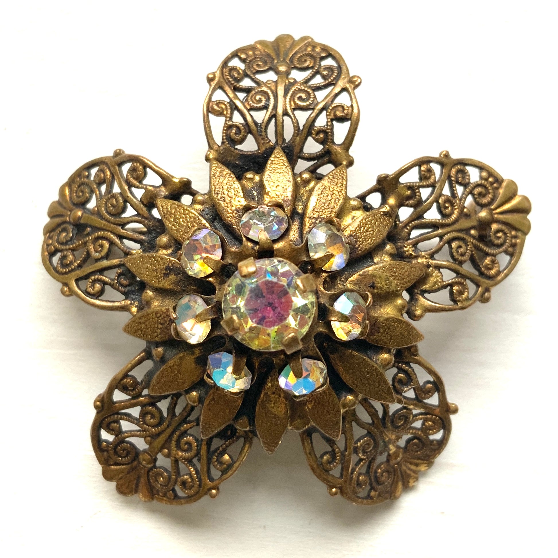 A beautifully detailed filigree flower brooch with a softly glowing aurora borealis centre.  フィリグリー×オーロラストーンのフラワーブローチ。