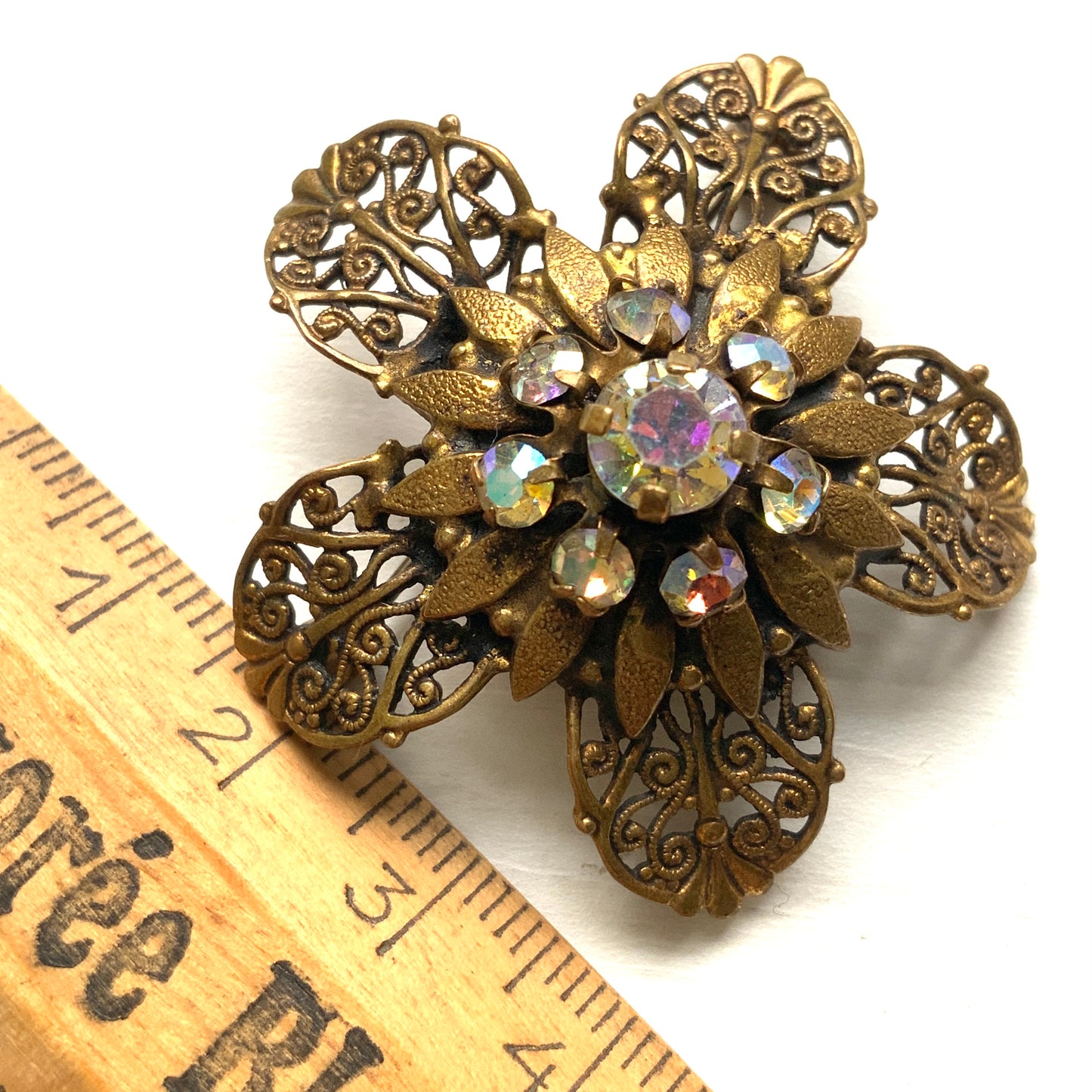 A beautifully detailed filigree flower brooch with a softly glowing aurora borealis centre.  フィリグリー×オーロラストーンのフラワーブローチ。