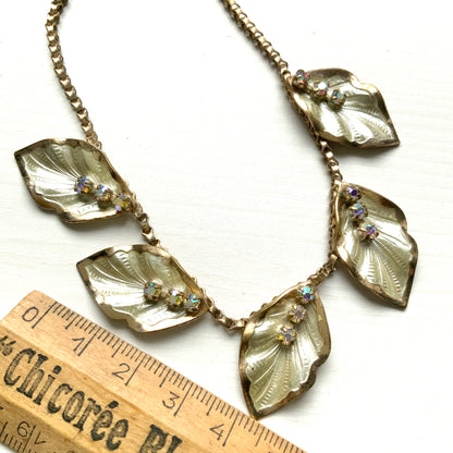 A graceful vintage necklace featuring leaf motifs in gold-tone metal with pearl white enamel detailing. エナメルリーフ×オーロラストーンのネックレス。
