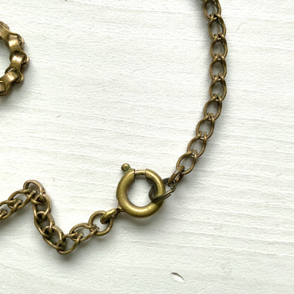 A graceful vintage necklace featuring leaf motifs in gold-tone metal with pearl white enamel detailing. エナメルリーフ×オーロラストーンのネックレス。