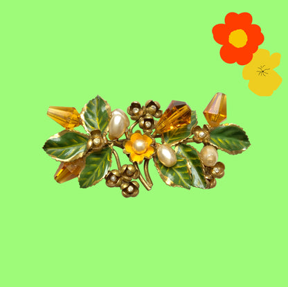 A floral brooch adorned with green enamel leaves, amber glass beads, and faux pearls. グリーンのエナメルリーフに、アンバーグラスビーズやグラスパールをあしらったフラワーブローチ。