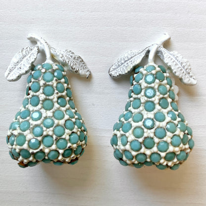 White pear-shaped clip earrings set with turquoise glass stones. ターコイズカラーのガラスストーンが散りばめられた、白い洋梨モチーフのクリップイヤリング。
